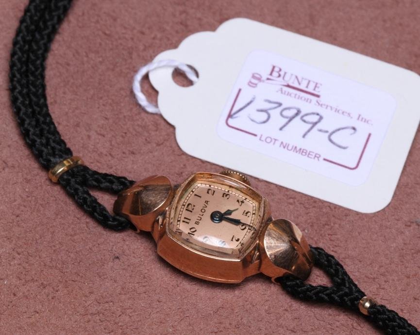 LADY'S BULOVA 14K ROSE GOLD WRISTWATCH: Having jeweled movement, stem wound and set, with Arabic numeral markers on rose gold finish dial, contained in 14K rose gold case, fitted with cloth straps.
