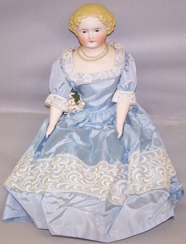 PARIAN WARE HEAD DOLL: Having painted blue eyes, closed mouth, molded and painted blond hair, cloth body with bisque lower arms and lower legs with molded and painted black boots, marked ''U'', approximate height 22''.