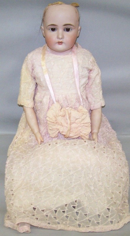 JD KESTNER BISQUE HEAD DOLL: Having fixed eyes, open mouth with teeth, cloth body with bisque lower arms, marked ''11 166'', approximate height 22''.