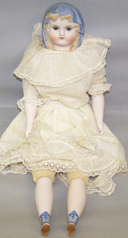 EMMA CLEAR PARIAN WARE HEAD DOLL: Reproduction blue bonnet doll, having fixed glass eyes, closed mouth, molded hair and blue bonnet, cloth body with bisque arms and lower legs with molded and painted blue boots, head marked ''CLEAR'',
