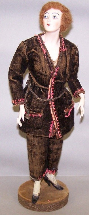 BISQUE HEAD FLAPPER DOLL PINCUSHION: BISQUE HEAD FLAPPER DOLL PINCUSHION| Having side-glancing head and eyes, painted blue eyes, closed mouth, cloth body with bisque lower arms and composition lower legs with molded and painted high heel