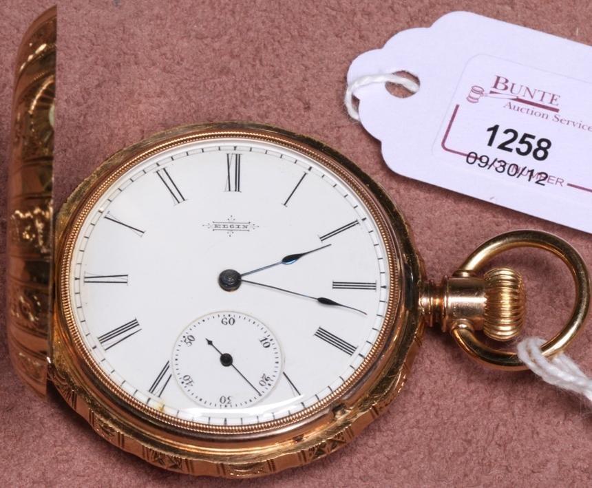 ***ELGIN 14K YELLOW GOLD POCKET WATCH: Having jeweled movement, stem wound and lever set, with Roman numeral markers and second subsidiary on a white finish dial and contained in a 14K yellow gold hunter case with engraved decoration.
