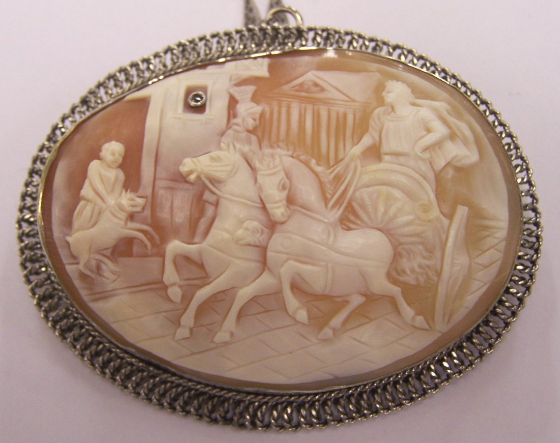 ***VICTORIAN STYLE CAMEO/PENDANT: Depicting rider in chariot, mounted in a silver frame, suspended from a silver finish chain, approximate cameo size 2 5/8" x 2". CONDITION: Good. Estimate $100-150>