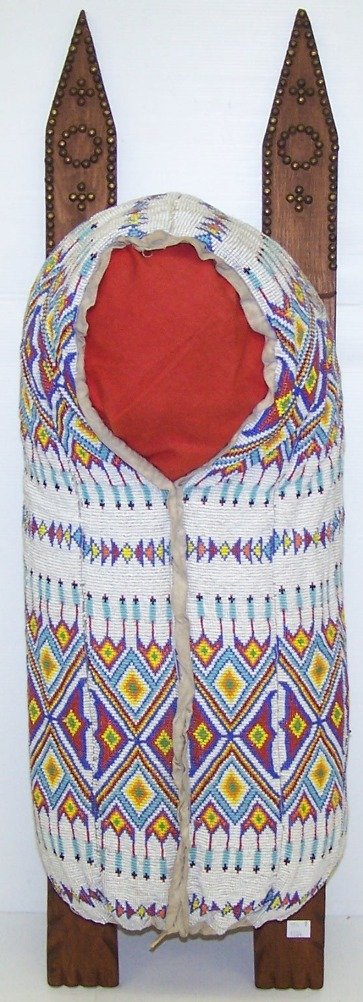 ***CONTEMPORARY BEADED CRADLE BOARD: Having small diamond and feather motif, in colors of red, yellow, green, blue on white ground, approximate total length 35''.