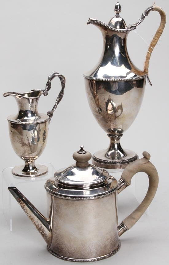 ***GEORGE III ENGLISH SILVER TEAPOT: By James Young, dated 1776, fitted with wood handle and finial together with a companion wine jug and creamer, approximate total weight 37 troy oz.