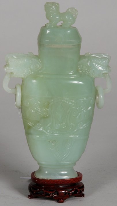 ***CHINESE GREEN JADE COVERED URN: ***CHINESE GREEN JADE COVERED URN| Fitted with Foo dog form finial, raised on hardwood base, approximate urn height 6".