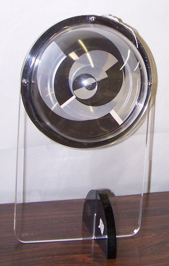 ***BORIS TABACOFF MANTEL CLOCK|: ***BORIS TABACOFF MANTEL CLOCK| Enclosed in Plexiglas case, marked on base "B. Tabacoff J. Esquive, Paris", approximate height 15".