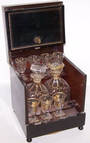 *FRENCH EBONY WOOD LIQUEUR SET: Opening to fitted interior with 2 decanters and 7 cordials, approx. height 9 1/2".