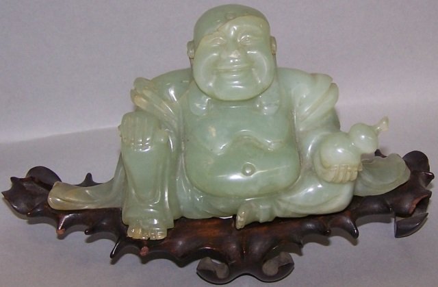*CARVED JADE SCULPTURE: Depicting happy fat man, raised on wood base, approximate height 2 3/4". CONDITION: Good. Estimate $ 100-200