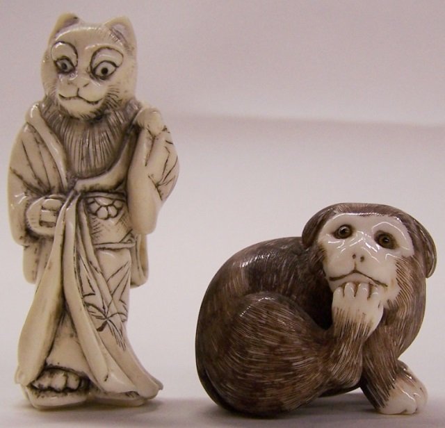 *2 CARVED IVORY NETSUKES: Cat in kimono and a recumbent monkey, both signed on underside. Note: Items containing ivory will only be shipped domestically and cannot be shipped to California.