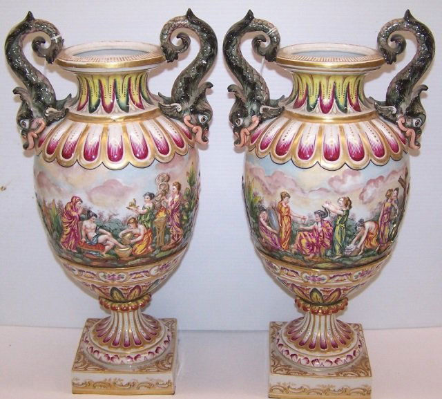 PAIR OF CAPODIMONTE POTTERY URNS: Having dragon form handles and relief decoration depicting figures and landscape, approximate height 17".