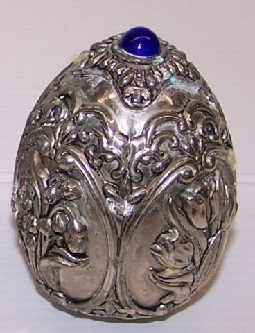 GORHAM SILVERED EGG: Surmounted with cobalt blue stone and having panels with assorted flowers, approximate height 3 1/4".