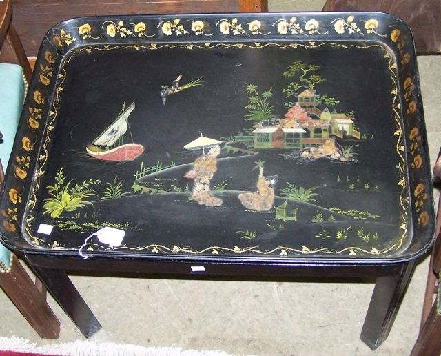 19TH C. TRAY TOP TABLE: With toleware tray having floral border centered with Oriental figures, architecture and landscape, raised on ebony base, approximate height 20", width 29 3/4", depth 22 1/4".