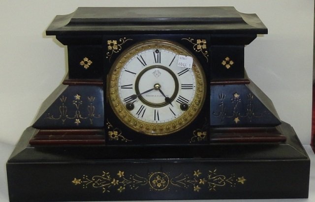 *ANSONIA MANTEL CLOCK: Fitted with time and strike movement, the enamel dial having Roman numeral markers, enclosed in slate case with incised gilt floral decoration, approximate height 11".