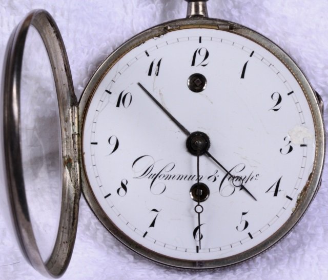 *DUCOMMUN & COMIN POCKET WATCH: *DUCOMMUN & COMIN POCKET WATCH| Having Fusee movement, key wound and set with numeral markers on white finish dial, contained in a silver open face case.