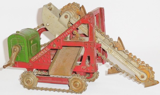 *KENTON CAST IRON BUCKEYE DITCHER: Painted red frame, green engine housing, gold embossed lettering, chain tracks, nickel plated wheels, digger boom and buckets, approximate length 9 1/2".