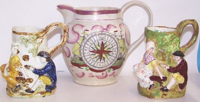 *3 19TH C. PORCELAIN AND POTTERY CREAMERS: 1 decorated with sailing ship and compass rose on verso and a pair with relief decoration depicting maidens in meadow, approximate height 6" and 5".