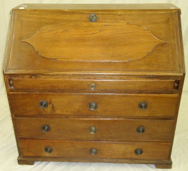 LATE 19TH C. OAK SLANT FRONT DESK: Having hinged writing surface opening to fitted interior of drawers and single door and 4 graduated drawers below, approximate height 43 3/4", width 45", depth 23 1/2".