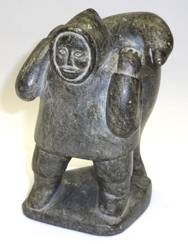 *INUIT CARVED STONE SCULPTURE: Figure carrying walrus, approximate height 7".