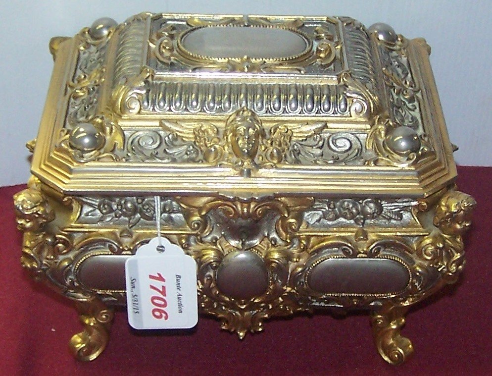 *FRENCH STYLE BRASS DRESSER BOX: Having musical movement, decorated with cherub, masks and leafy scroll work, approximate height 6", width 8", depth 7".