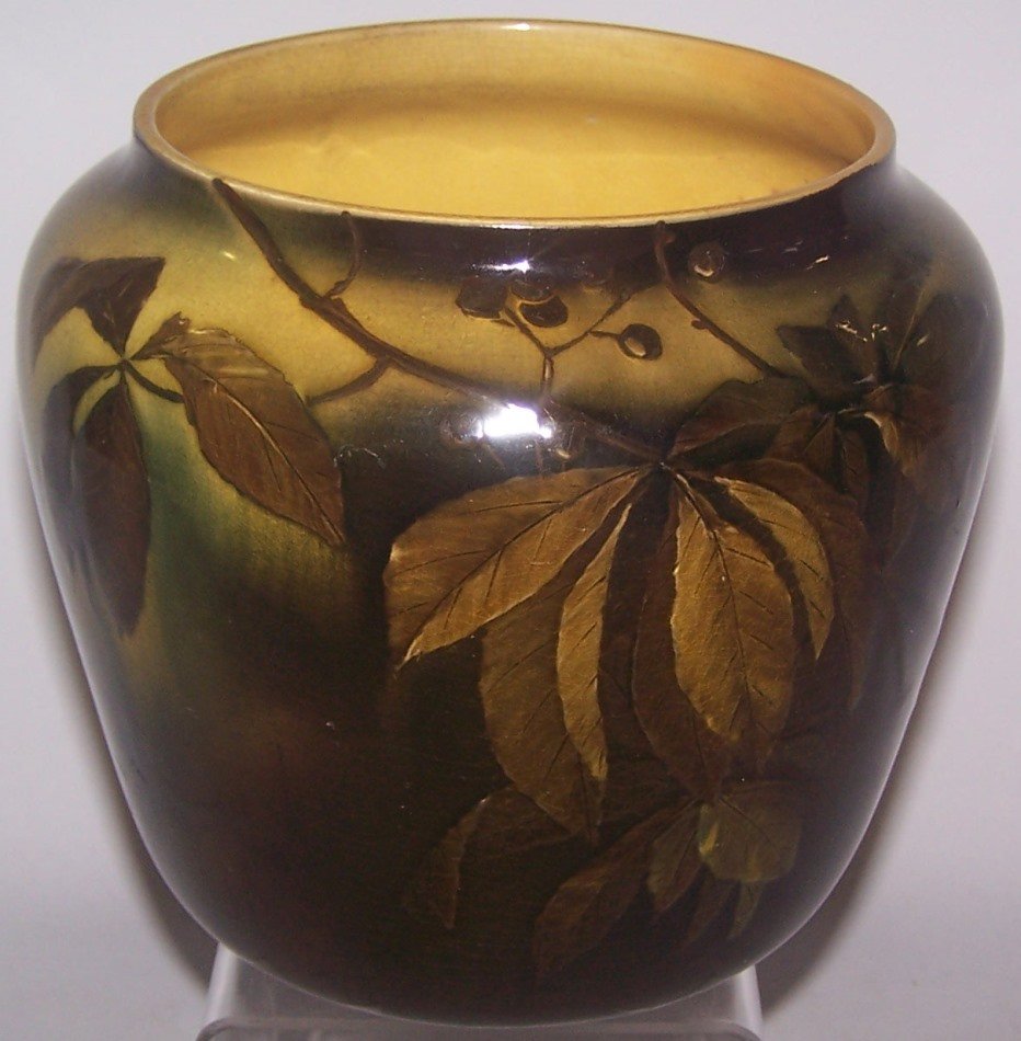 *ROOKWOOD ART POTTERY JARDINIERE: Decorated by Anna M. Valentien, having standard glaze with leaves and berries on a brown and green ground, marks include impressed Rookwood flame logo indicating date 1892, shape #180 D, signed with a