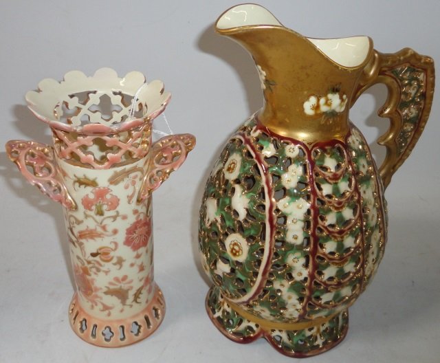 2 PIECES OF ZSOLNAY POTTERY: Pitcher with gilt handle and floral decoration, approximate height 10", and cylindrical vase having reticulated body, marked on underside, height 7 3/4".