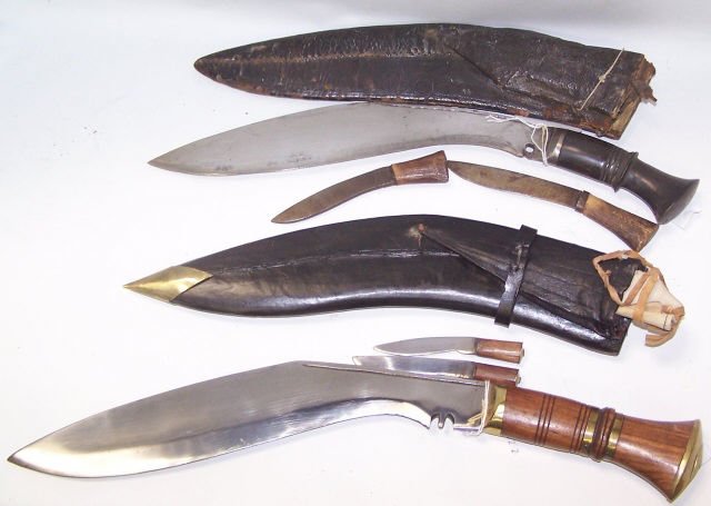 *2 NEPALESE KUKRI KNIVES: 1 having carved wood handle with polished brass mounts, leather scabbard with brass mounts and 2 knives, approximate length 18", and 1 having carved wood handle with silvered metal mounts, leather sca