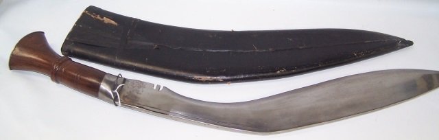 *NEPALESE KUKRI KNIFE: Steel blade, having carved wood handle, leather scabbard having brass mount, approximate length 31 1/2".