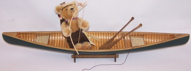 *STEIFF TEDDY BEAR: "The Last Mohican", with tags, canoe and paddles, approximate length of canoe 27 1/2".