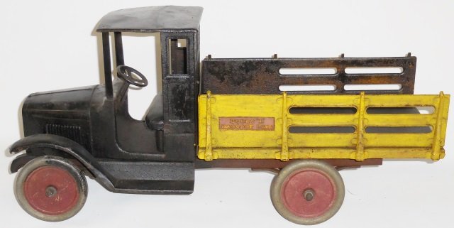 *BUDDY L PRESSED STEEL BAGGAGE TRUCK: Black body with red stake bed, red disc wheels, approximate length 25".