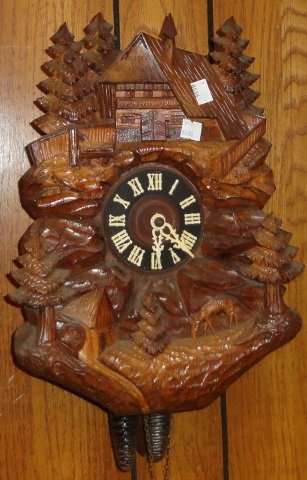 *BLACK FOREST CUCKOO CLOCK: Fitted with time and strike movement, wood dial having Roman numeral markers, enclosed in figural case depicting chalet, flora and fauna.