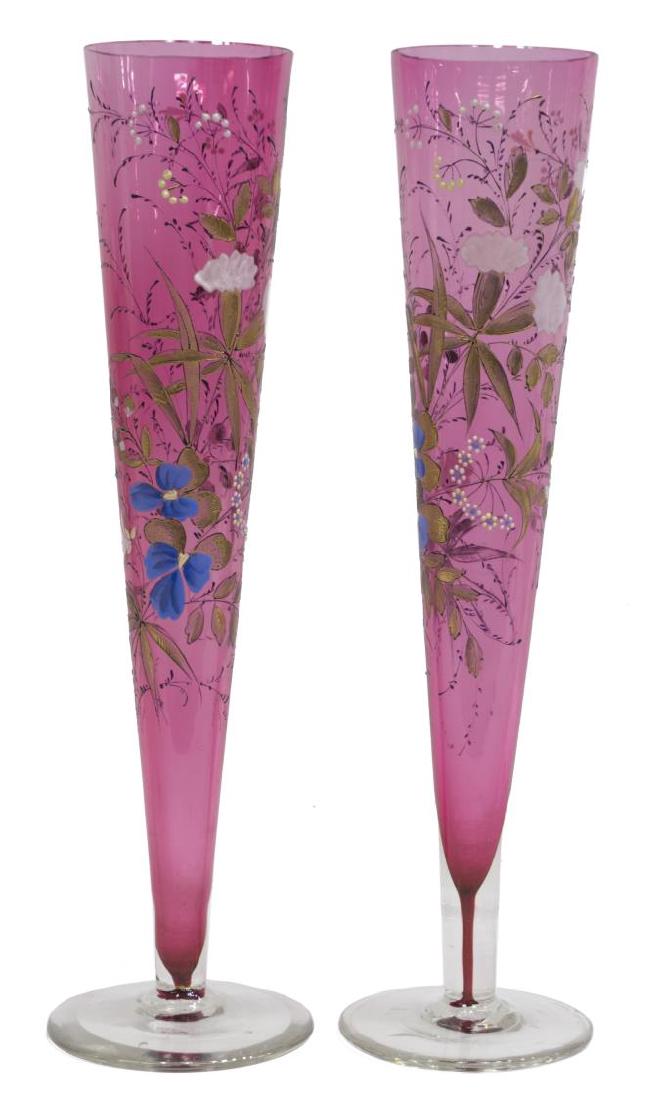 (2) TALL CRANBERRY ENAMELED GLASS TRUMPET VASES: (pair) Cranberry glass trumpet vases, each gilded and enameled with flowering plants and vines in the manner of Moser, on a colorless circular foot, old bubbles to glass, 16"h, 2.75lbs total Start Pri