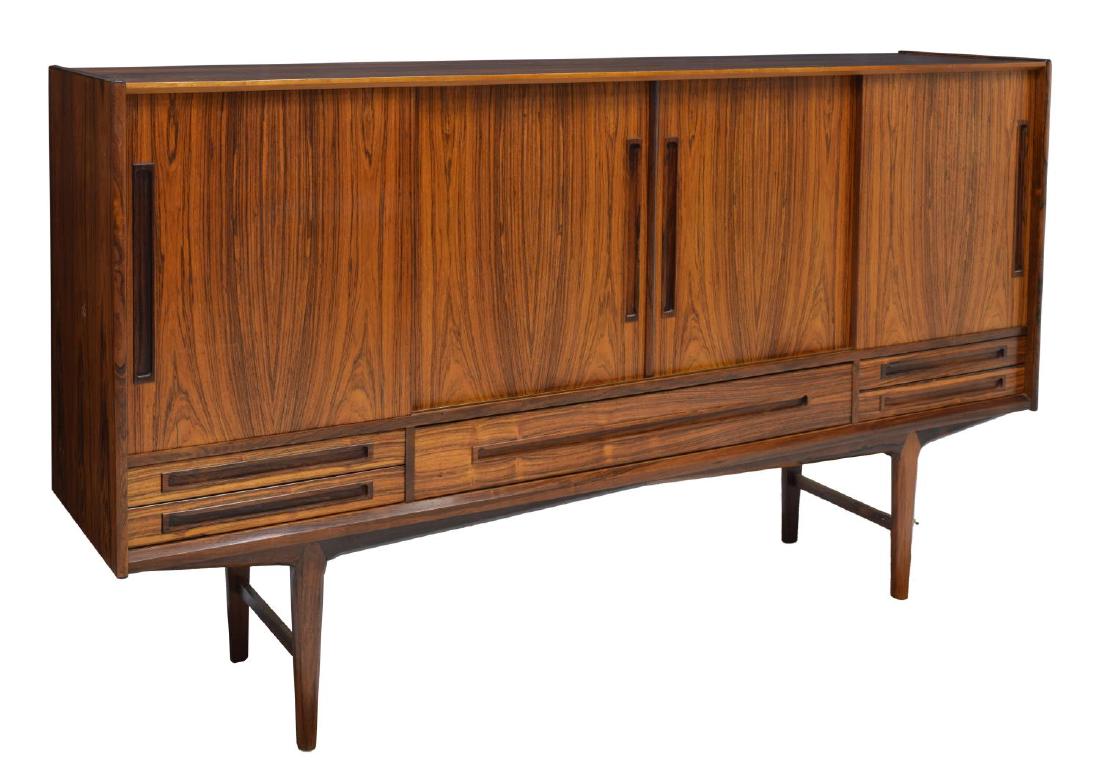 DANISH MID CENTURY MODERN ROSEWOOD SIDEBOARD: Danish mid century modern rosewood sideboard, the rectangular case fitted with four sliding doors, concealing shelved interior, all over four short drawers and one long drawer, rising on tapered legs,