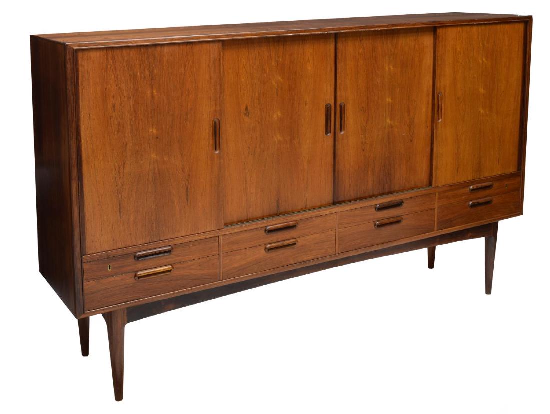 DANISH MID-CENTURY MODERN ROSEWOOD SIDEBOARD: Danish mid-century modern rosewood sideboard, c. 1950's, rectangular case fitted with four sliding doors concealing shelving and drawers, over drawers, rising on cylindrical tapered legs, approx 48"h,