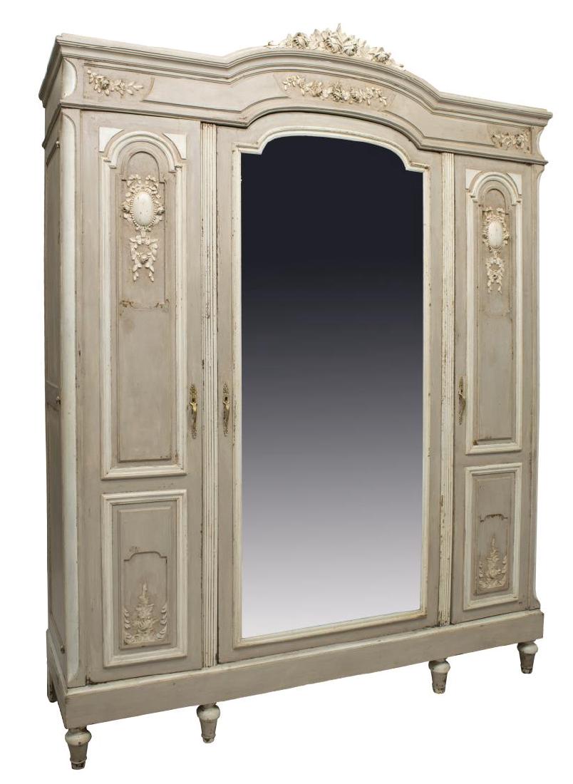 ANTIQUE LOUIS XVI STYLE PAINTED ARMOIRE: Louis XV style armoire, early 20th c., with an antiqued painted finish, having a floral and foliate cornice over a central mirrored door flanked by paneled doors with interior mirrors, all rising on t