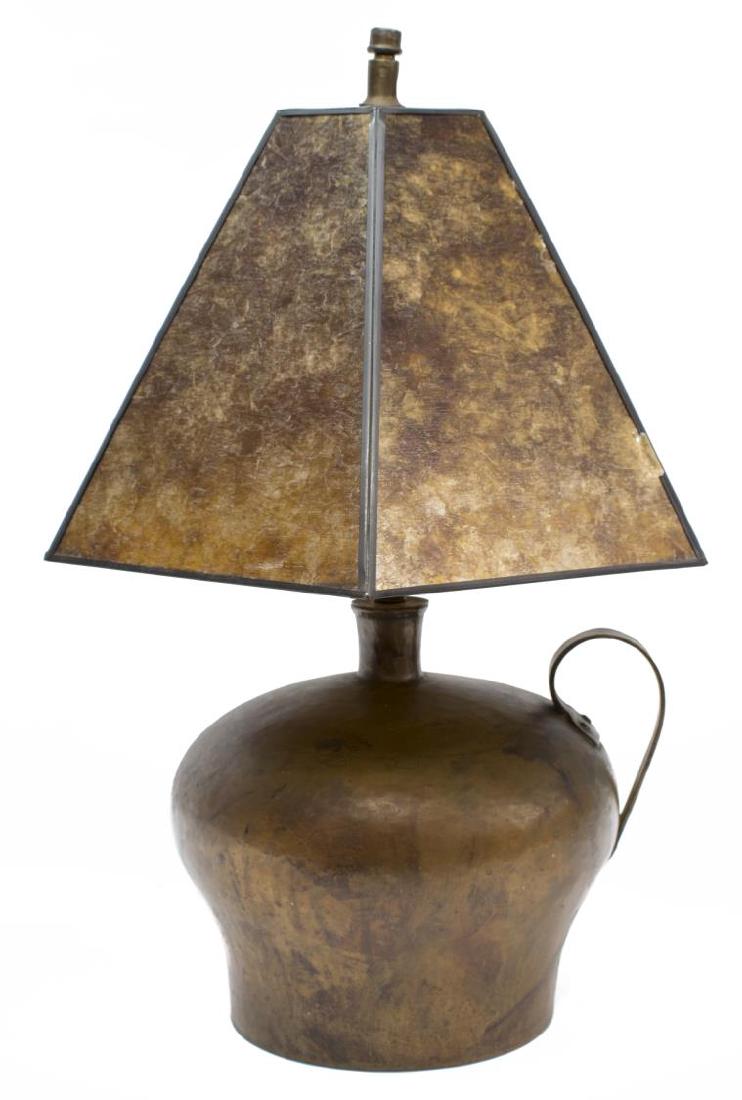 ARTS & CRAFTS HAMMERED COPPER JUG TABLE LAMP: Arts and Crafts hammered copper table lamp, having a brown glass paneled shade over a single light, above the copper jug form body, with applied handle to side, overall: 19.5"h, 13.5" diam., 5.25lbs S