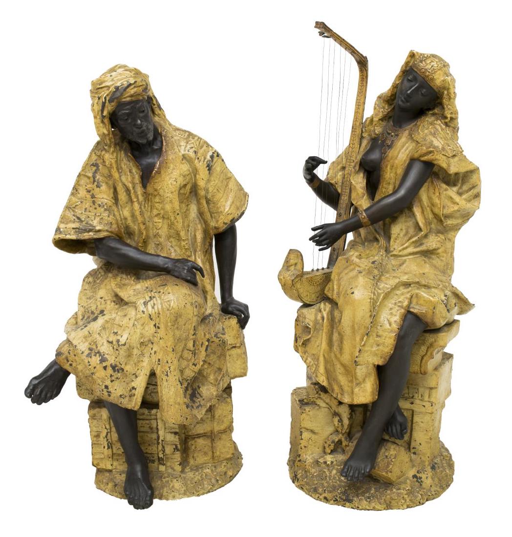 (2) COLD PAINTED METAL ORIENTALIST FIGURES, 36"H: (lot of 2) Cold painted Orientalist metal man and woman, c, 1900, figures, each seated on rock form, he in contemplation, she playing a harp like instrument, both with ebonized features and wearing Ar