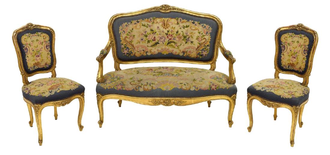 FRENCH LOUIS XV STYLE CARVED GILTWOOD SALON SUITE: French Louis XV style floral carved gilt wood salon set consisting of a settee and 2 side chairs, all upholstered in floral needlepoint tapestry, late 19th / early 20th century, each chair: 36.5"h, 18