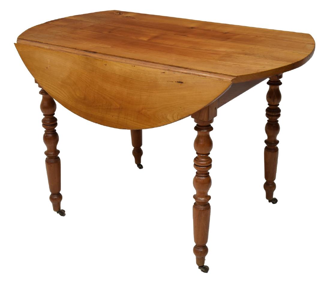 FRENCH CHERRYWOOD DROP LEAF CIRCULAR SIDE TABLE: French drop leaf side table, 19th c., executed in cherrywood, the circular top over turned legs on casters, approx 29.5"h, 44"diam, with leaves dropped: 25"w Start Price: $100.00