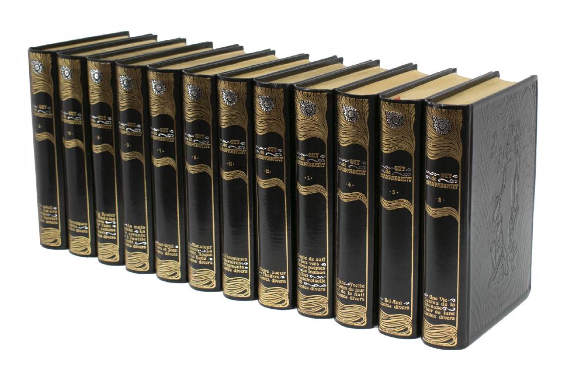 (12) ART NOUVEAU STYLE BLACK LEATHER LIBRARY BOOKS: (lot of 12) French Art Nouveau style black embossed leather bound library books set, The Complete Works by Guy de Maupassant, with gilt edged pages and lettering to spine, each: approx 8.5"h, 1.5"w, 6