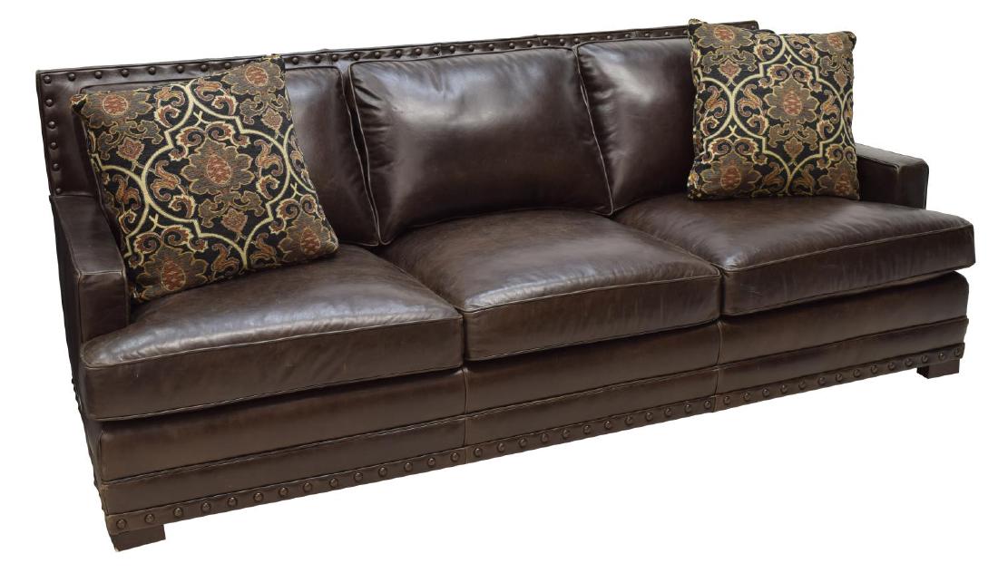 LEATHER THREE CUSHION SOFA: Contemporary dark brown leather sofa, three removable seat and back cushions, nail head accents, two multi-color accent pillows, rising on block supports, 36"h, 92"w, 36"d Start Price: $300.00