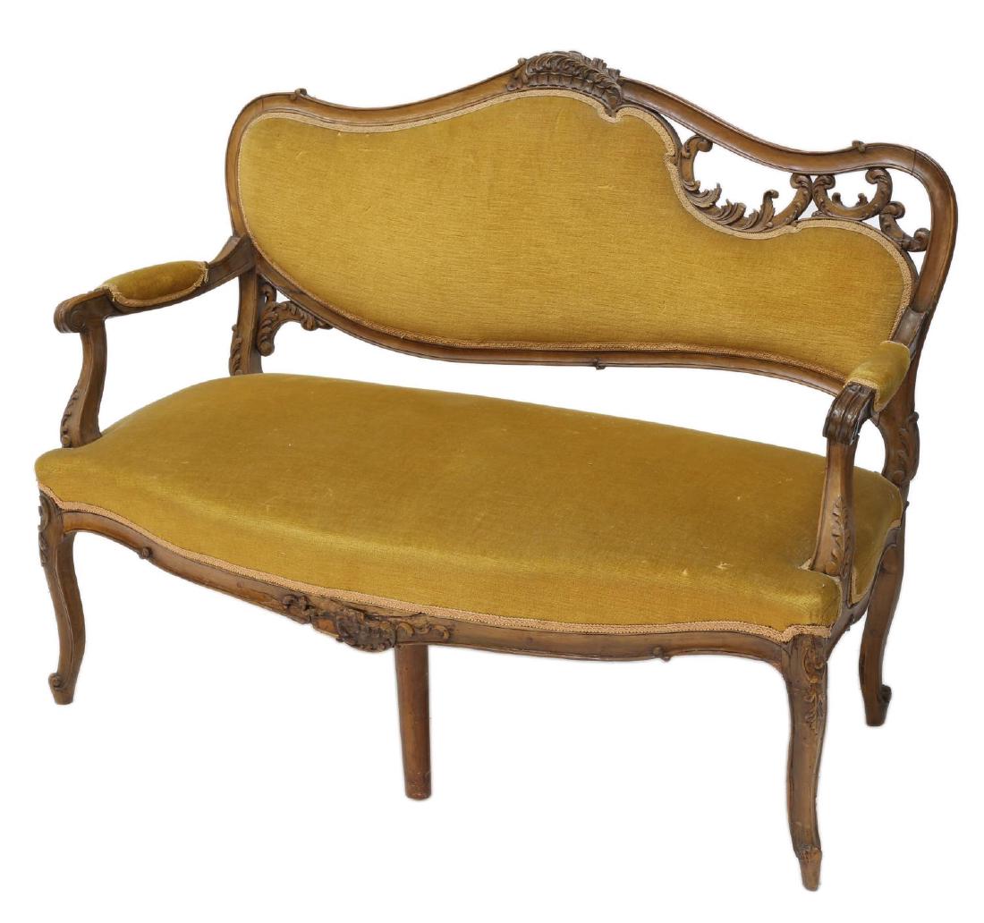 LOUIS XV STYLE CARVED SETTEE: French Louis XV style walnut framed settee, late 19th c., the foliate and pierced carved crest rail over the gold done fabric back and seat framed by padded arms, rising on scroll foot cabriole legs, 