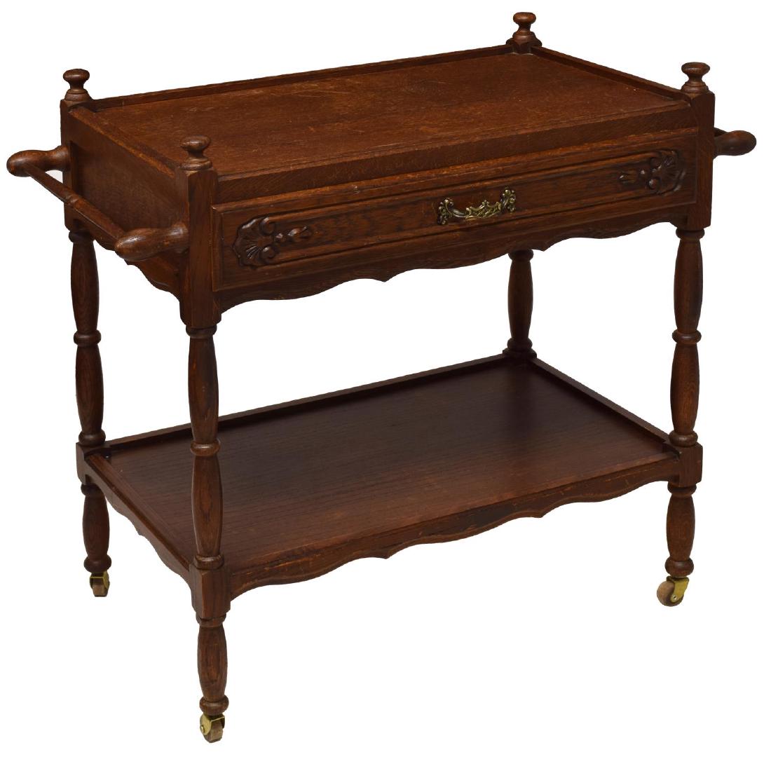 OAK SERVICE CART: Oak service cart, rectangular with towel bars at each end, a frieze drawer over a lower shelf, rising on turned legs with castors, 28.25"h, 31"w, 16.5"d **Provenance: The private collections of a prom