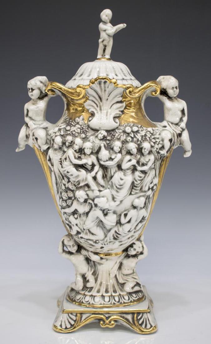 ITALIAN CAPODIMONTE PORCELAIN LIDDED HANDLED VASE: Italian Capodimonte porcelain vase, 20th c., with lid surmounted by figural finial over flared parcel gilt foliate rim, tapering body with figural reliefs and figural handles, resting upon pedestal fo