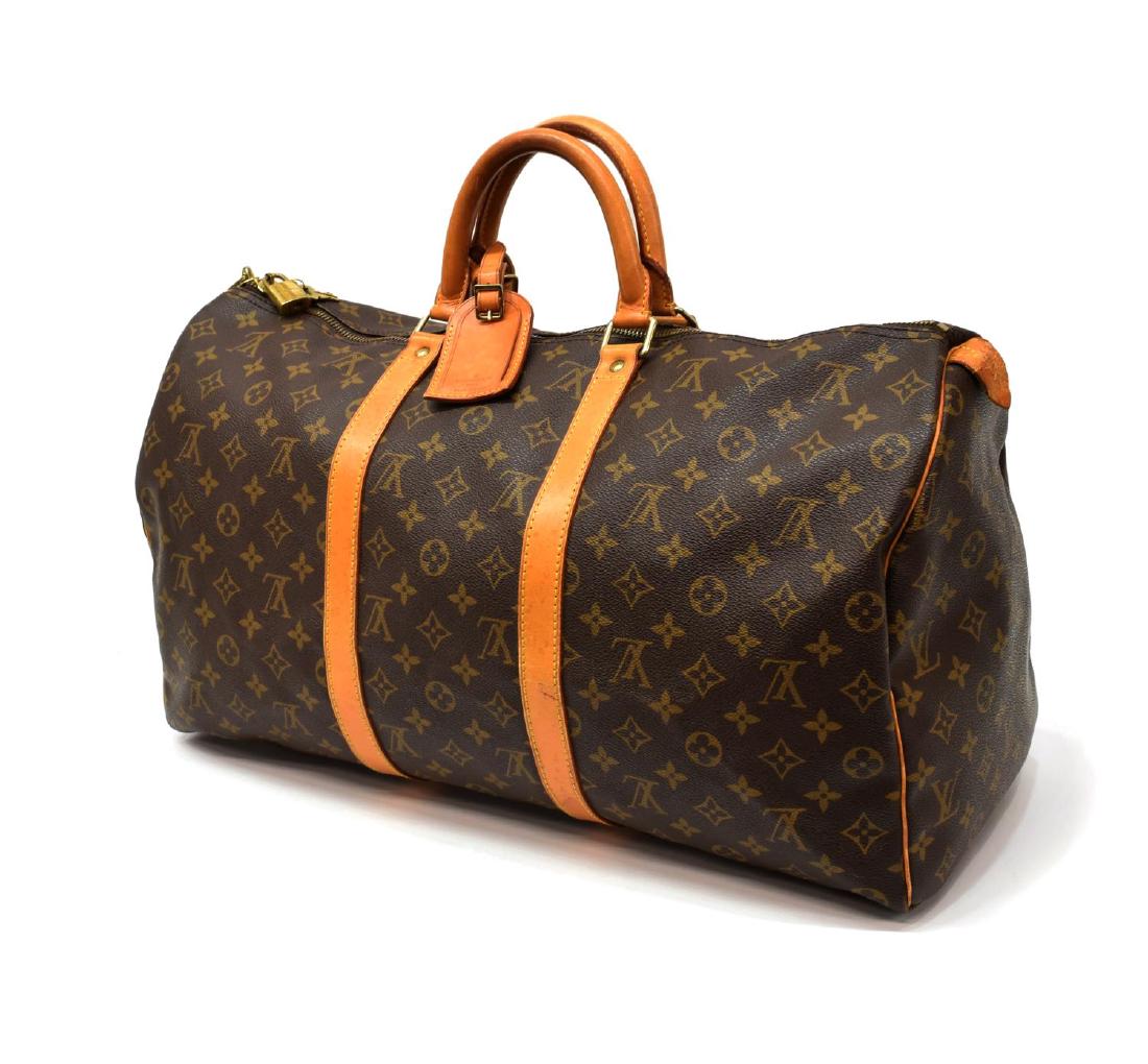 LOUIS VUITTON 'KEEPALL' MONOGRAM DUFFLE BAG: Louis Vuitton "Keepall" traveling duffle bag in monogram canvas, having leather handles, trim, and piping, zipped top opening to brown fabric interior, retaining luggage tag, handle strap, lock and ke