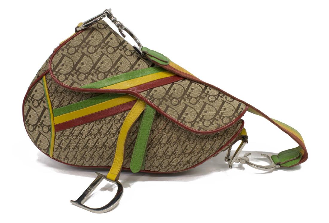 CHRISTIAN DIOR DIORISSIMO RASTA SADDLE BAG: Christian Dior saddle bag in Diorissimo patterned canvas with Rasta leather trim, having silver tone hardware, large "D" charm, single woven handle held with "C.D." hardware, velcro flap opening to li
