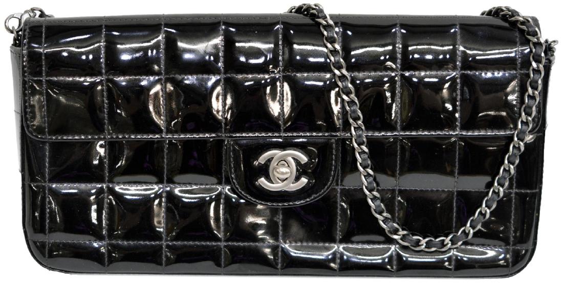 CHANEL QUILTED BLACK PATENT EAST WEST FLAP BAG: Chanel East/ West flap bag in quilted black patent leather, with matte silver tone hardware, having classic chain leather strap, flap with "CC" turnlock opening to black satin lined interior with two