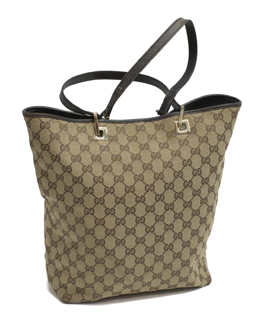 GUCCI MONOGRAM GG CANVAS BUCKET TOTE BAG: Gucci bucket tote bag in brown monogrammed canvas, with silver tone hardware, having black leather bottom and double flat top handles, opening to black textile lined interior with single zipper pocket