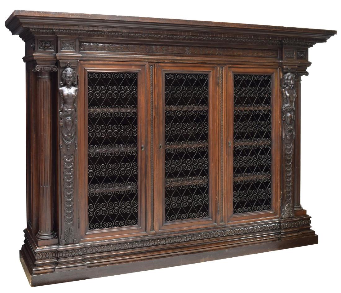 ITALIAN RENAISSANCE REVIVAL CARVED BOOKCASE: Renaissance revival carved bookcase, Italy, early 20th c., having stepped cornice top, over frieze with dentil molding and carved foliate garland, cabinet flanked on either side with fluted ionic colu