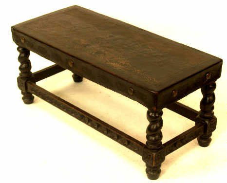 PERUVIAN LEATHER FIGURAL BENCH TABLE TWIST LEGS: A Peruvian bench or table with figural scene on hand tooled leather top. A primitive scene with mountains, two figures, llamas, and the sea with two sailing boats. Leather held with decorative tacks h